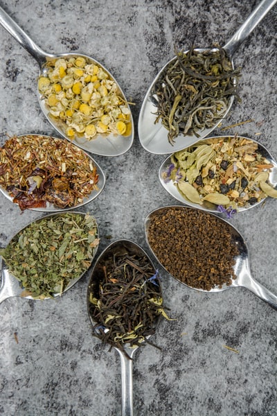 Seven different spices and herbs on grey stainless steel spoon

